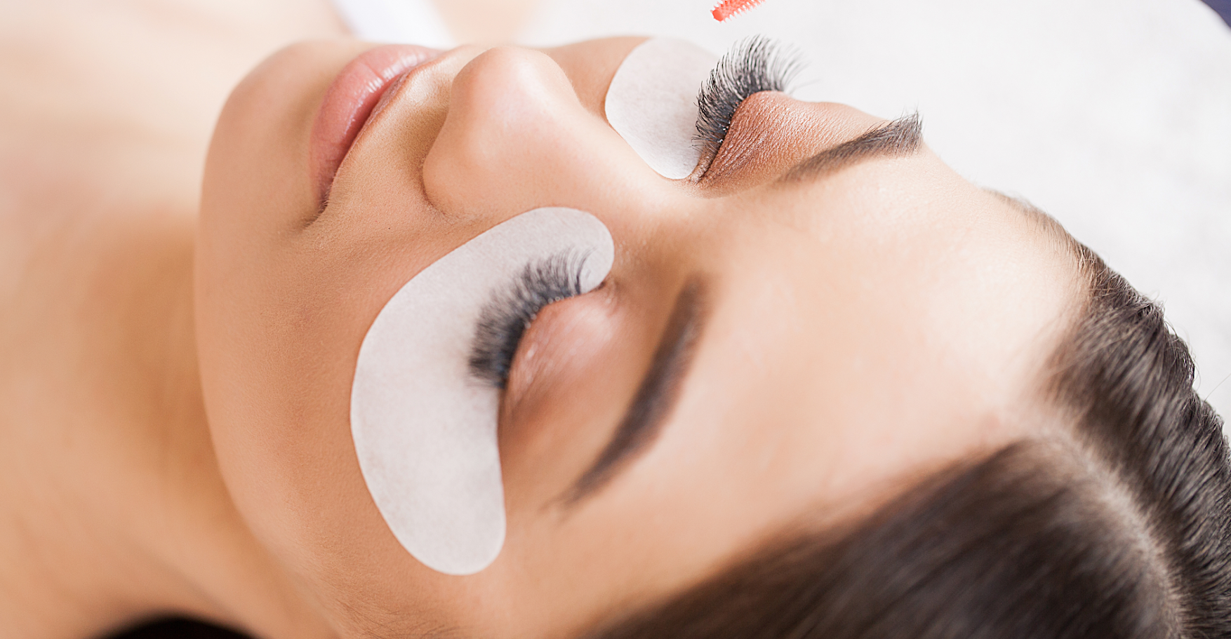 Women laying down receiving a lash and brow treatment